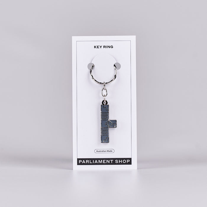 Silver and grey coloured key ring in the shape of Australian Parliament House on a white backing card.