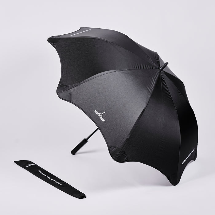 Open black umbrella with white Parliament House logo, next to a umbrella bag with logo and text reading 'Australian Parliament House'.