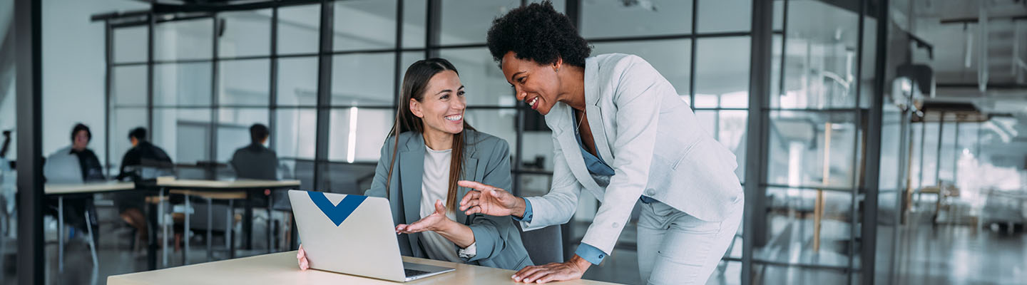 Two women using League Data’s digital banking services.