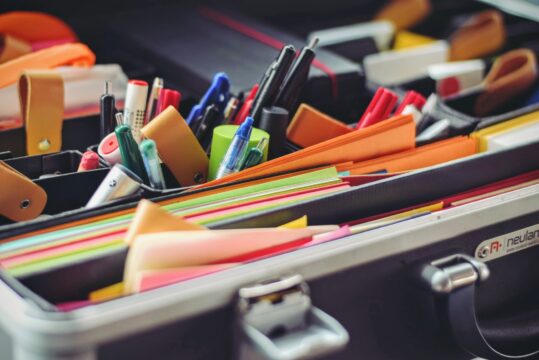 Pencils and post its in a box. Crayons et stylos dans une boite.