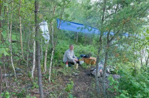 Graeme under tarp at Drinking Lake campsite