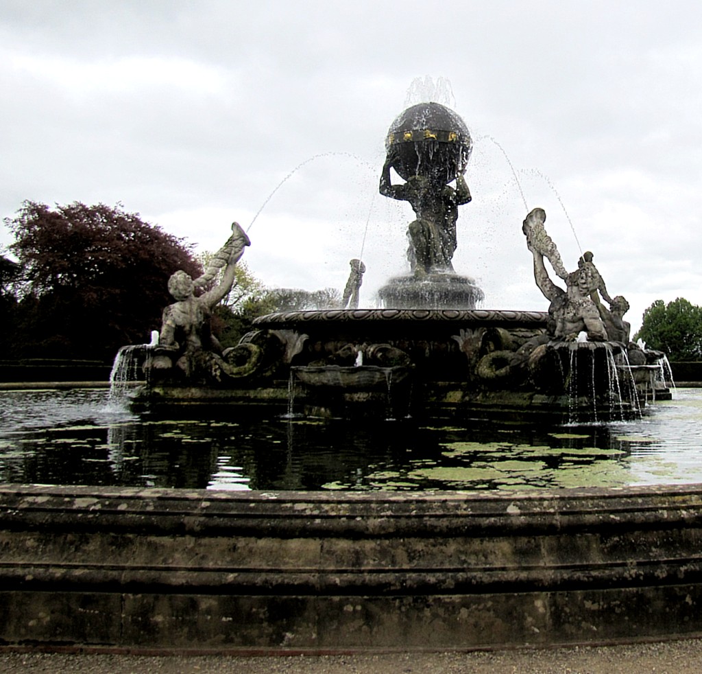 Atlas is in the centre, holding the world on his shoulders. Surrounding him are four tritons, spraying him with water. The tritons are about eight feet tall, so Atlas would be 10-11 feet tall if he were standing upright.