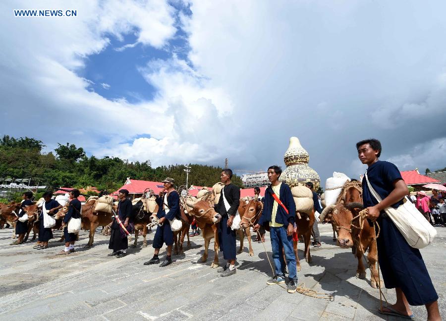 People transport rice during the 'new rice' festival, a traditional event of the Wa ethnic group to pray for harvest, in Cangyuan County, southwest China's Yunnan Province, Oct. 3, 2015. Cangyuan is one of the major areas inhabited by people of the Wa ethnic group. [Xinhua]