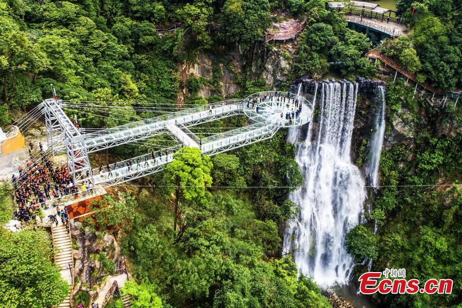 An aerial view of a glass viewing platform along a cliff at the Gulongxia scenic spot in Qingyuan City, South China\'s Guangdong province, June 28, 2018. The structure also features a massive circular glass observation deck suspended at the end of the bridge, jutting out 72 meters from the cliff edge. (Photo: China News Service/Zeng Linghua)