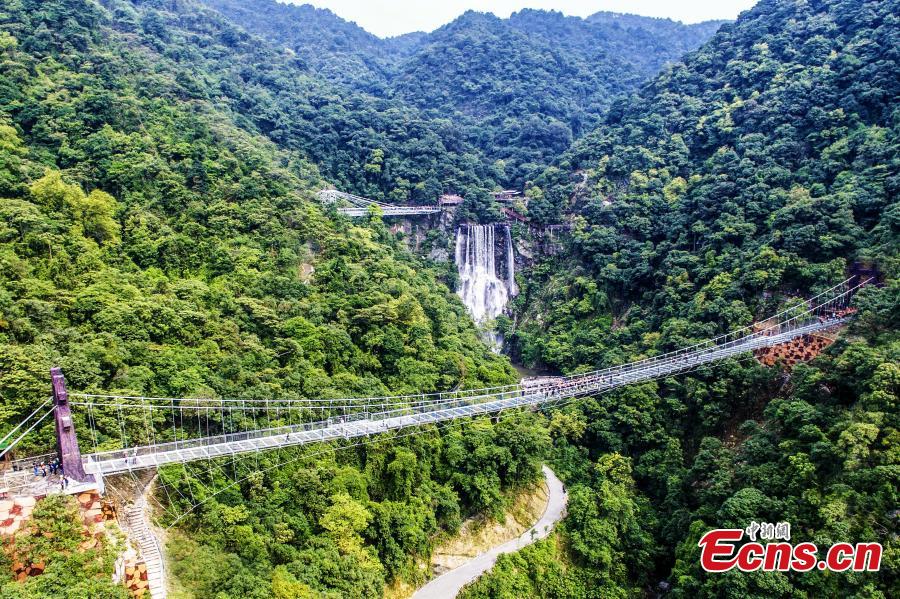 An aerial view of a glass viewing platform along a cliff at the Gulongxia scenic spot in Qingyuan City, South China\'s Guangdong province, June 28, 2018. The structure also features a massive circular glass observation deck suspended at the end of the bridge, jutting out 72 meters from the cliff edge. (Photo: China News Service/Zeng Linghua)