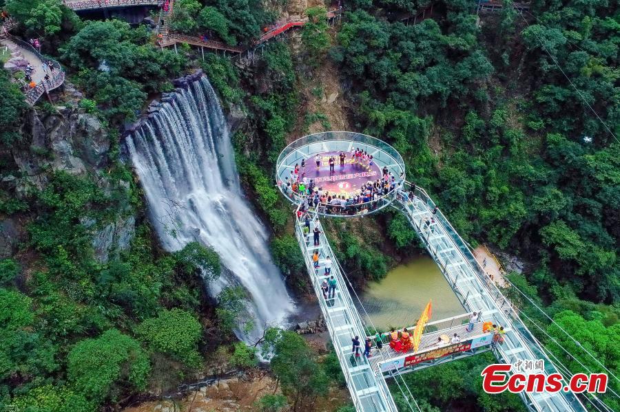 An aerial view of a glass viewing platform along a cliff at the Gulongxia scenic spot in Qingyuan City, South China\'s Guangdong province, June 28, 2018. The structure also features a massive circular glass observation deck suspended at the end of the bridge, jutting out 72 meters from the cliff edge. (Photo: China News Service/Xu Qingqing)