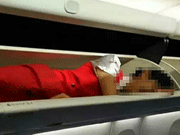 Air stewardesses packed into overhead bin