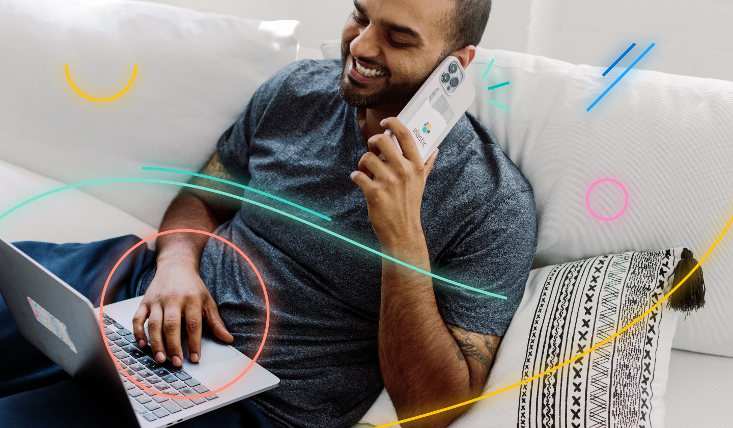 Smiling man works on computer and speaks on phone for his fully remote job