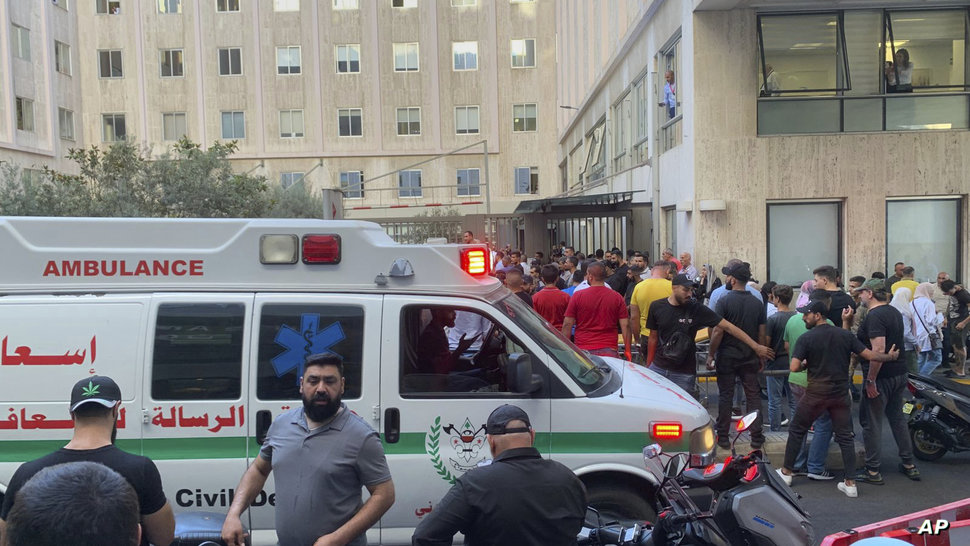 People gather outside the American University hospital after the arrival of several men who were wounded by exploded handheld…