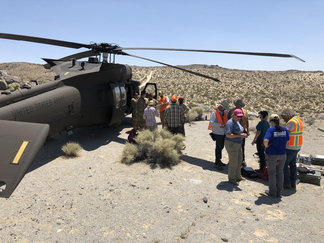 Scientists conversing by US Army helicopter 