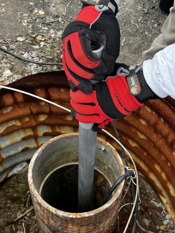 Color photograph of field engineer adjusting volcano-monitoring instrument