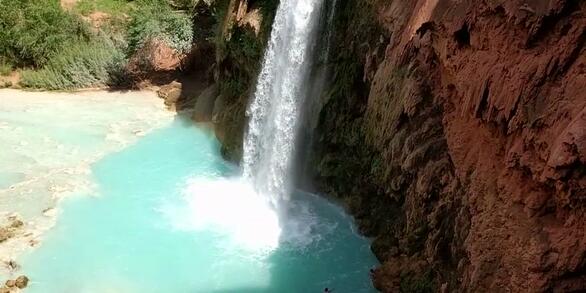 Photo of Havasu waterfall dropping into a light blue pool of water.