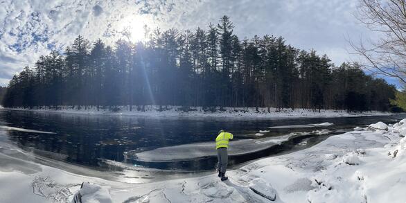 Lisle standing on edge of river conducting inspection