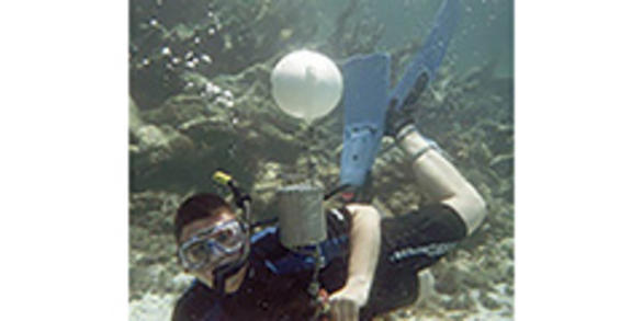 USGS Scientist deploys passive sampling device in aquatic environment