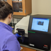 Scientist using a gene sequencer and an infographic of the process