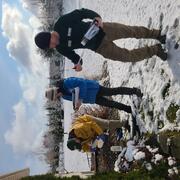 Three scientists collecting residential water well samples on sunny snowy day