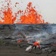 Color photograph of scientist sampling lava