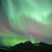 pastel lights in night sky over mountains