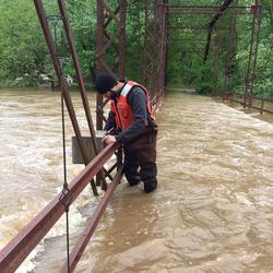 USGS Hydrologic Technician performing wire weight measurement during record flood at USGS gage 7018500