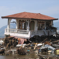 A home, severely damaged by the tsunami that hit Sumatra on December 26, 2004, sits atop debris.