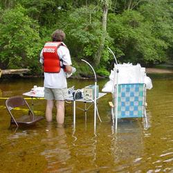 Scientist at research table set up in the river