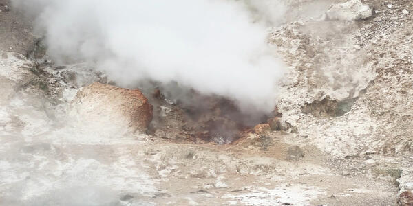 Steam rising from a hole within rocks