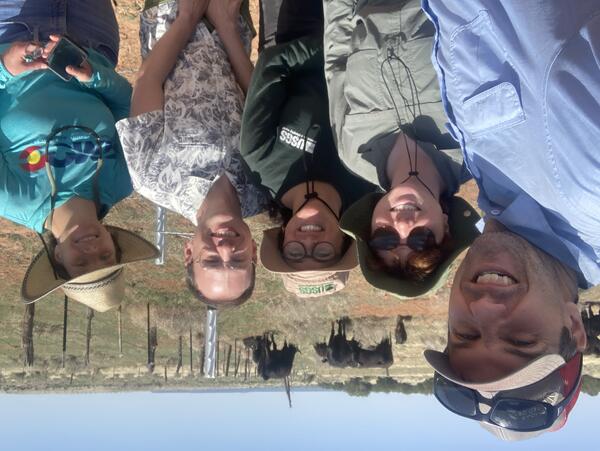 RAMPS employees and partners pose in front of a cattle grazing enclosure at a RestoreNet site