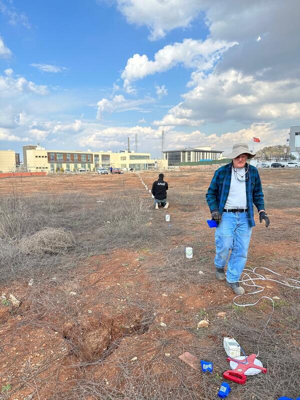 Scientists setting up an array of seismometers in a field. 