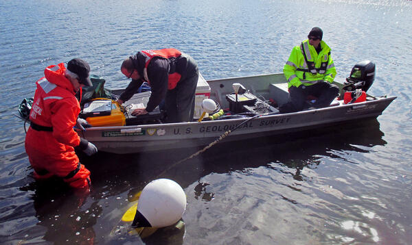 USGS scientists use a boat and geophysical equipment to record geological and hydrological conditions in a coastal embayment. 