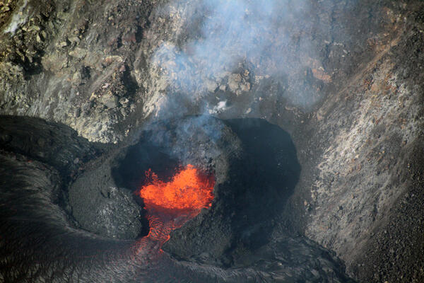 Telephoto color image of a lava fountain within a black spatter cone