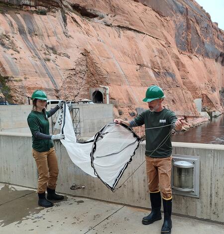 USGS scientist, Collin Smith, and USGS science technician, Georgia Martin, inspecting nets for catch at Glen Canyon Dam, AZ