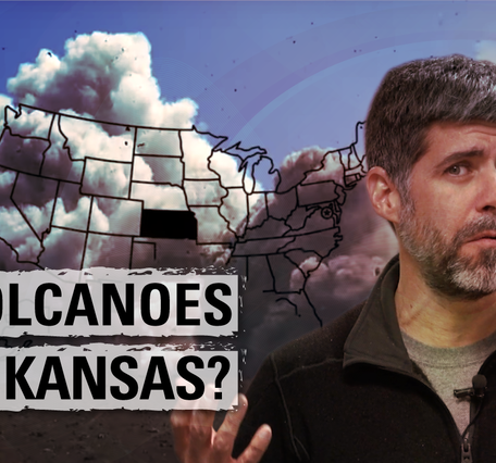 Man smirks with "Volcanoes in Kansas?" on top of a U.S. map with volcanic eruption in the background.