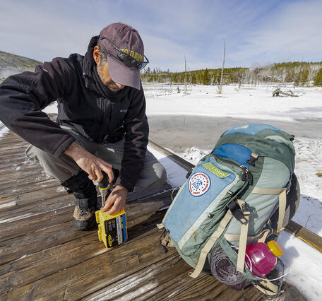 YVO scientist replaces batteries in a temperature logger (Norris Basin)