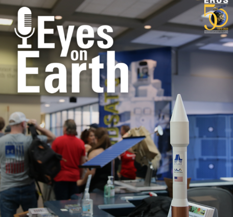 A rocket sits in the foreground of people visiting a data center