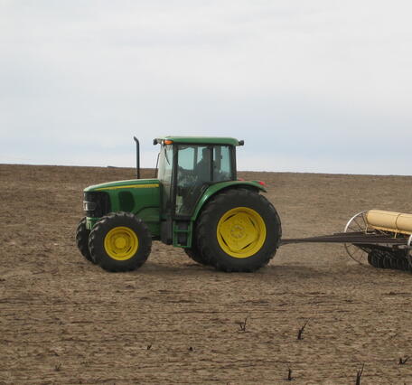 photo of a tractor and soil tiller