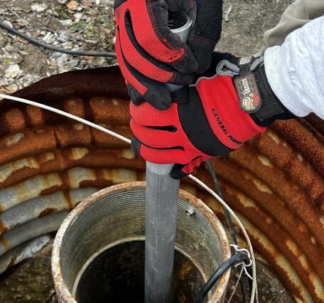 Color photograph of field engineer adjusting volcano-monitoring instrument