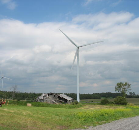 wind turbine next to a dilapidated barn