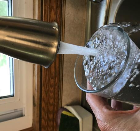 water glass filling in kitchen sink