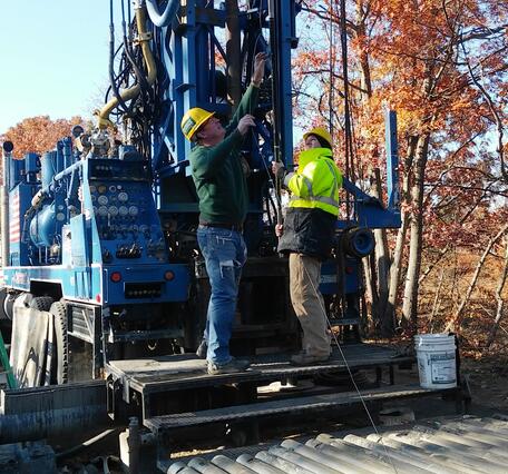 2 men standing on drill rig