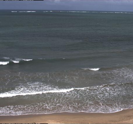 Photo of a beach with gently breaking waves.