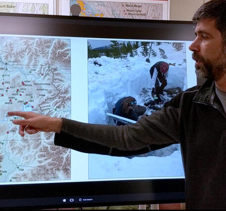 Man pointing to a map Yellowstone on a TV screen