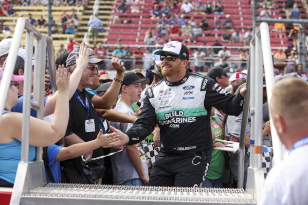 Chris Buescher greets fans while walking to his car before a NASCAR Cup Series auto race, Sunday, Sept. 15, 2024, in Watkins Glen, N.Y. (AP Photo/Lauren Petracca)