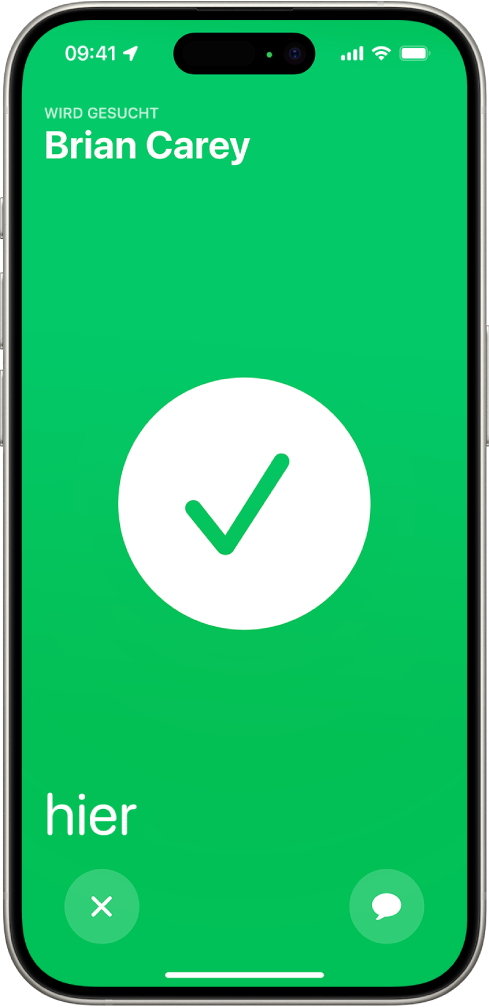 Der iPhone-Bildschirm ist grün und in der Mitte befindet sich ein großes Häkchen. Der Name der Person, die geortet wird, steht oben links und das Wort „hier“ befindet sich unten links und gibt an, dass das Treffen erfolgreich war.