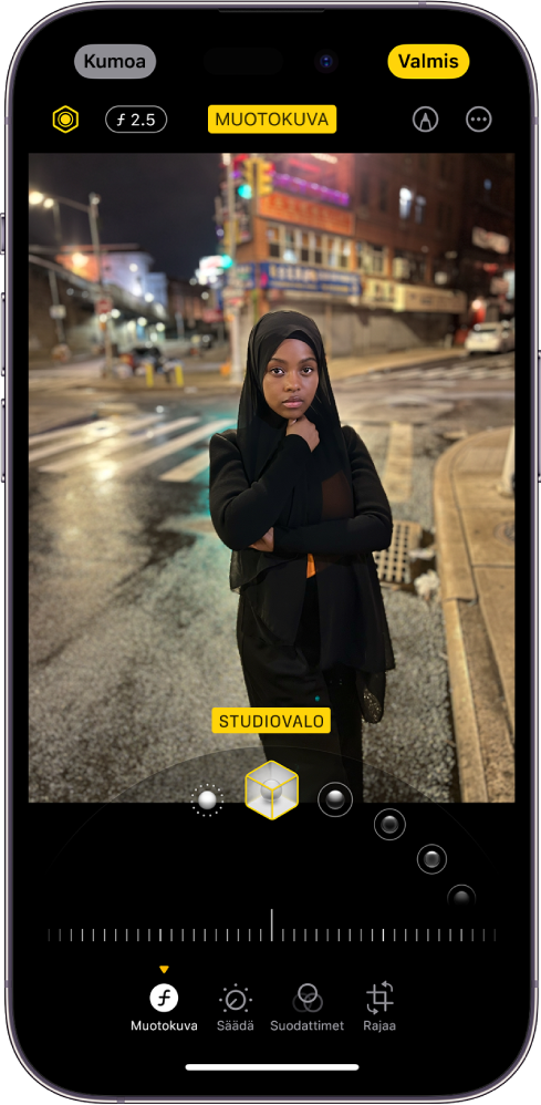 Muotokuvan muokkausnäyttö. Kuva on näytön keskellä, ja sen alapuolella ovat muotokuvan valaistuksen valinnat. Valittuna on Studiovalo. Sen alapuolella on liukusäädin tehosteen tason säätämiseen. Näytön alareunassa vasemmalta oikealle lueteltuina ovat Muotokuva-, Muokkaa-, Suodattimet- ja Rajaa-painikkeet. Valittuna on Muotokuva-painike.
