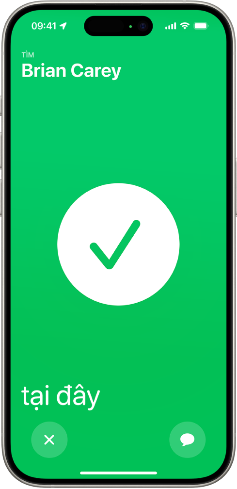 Màn hình iPhone có màu lục với một dấu kiểm lớn ở giữa màn hình. Tên của người đang được định vị nằm ở góc trên cùng bên trái và từ “ở đây” nằm ở góc dưới cùng bên trái, cho biết rằng việc tìm gặp đã thành công.