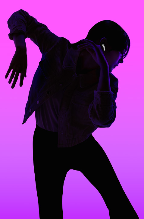 Silhouette d’une personne en train de danser, le bras gauche levé et plié avec l’avant-bras vers le bas, et le bras droit plié avec l’avant-bras vers le haut, son visage rétroéclairé en violet mettant en valeur l’écouteur des AirPods bien calé dans l’oreille droite.