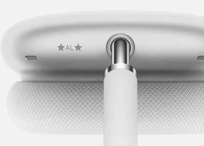 Graverade initialer högst upp på öronkåpan på AirPods Max i silver.