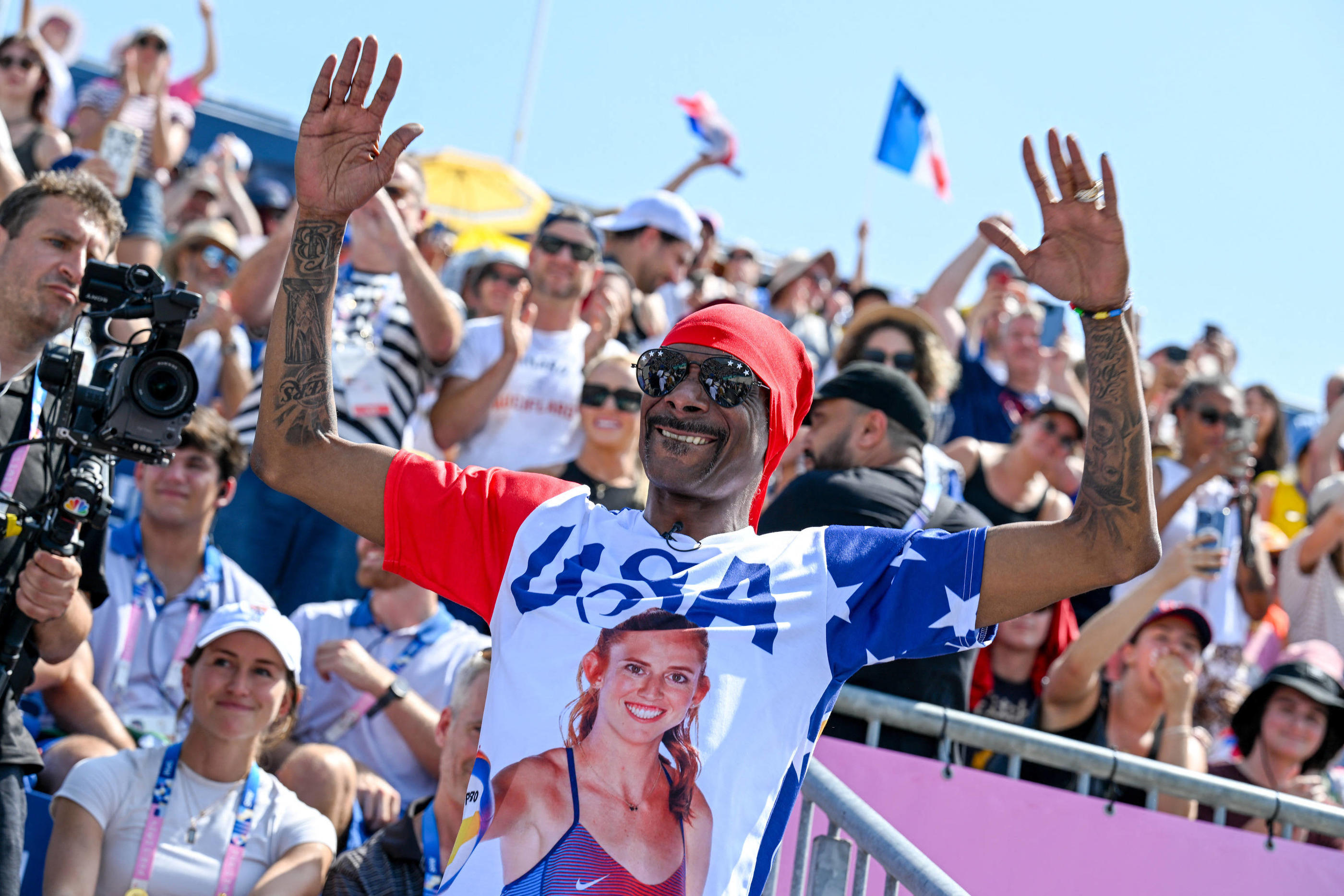 Paris (VIIe), mercredi 31 juillet. Quand il ne commente pas sur NBC, Snoop Dogg soutient les athlètes américains, en portant des t-shirts à leur effigie, comme ici au Stade Tour-Eiffel pour du beach-volley. Icon Sport/ABACA/Imago/Tom Bloch