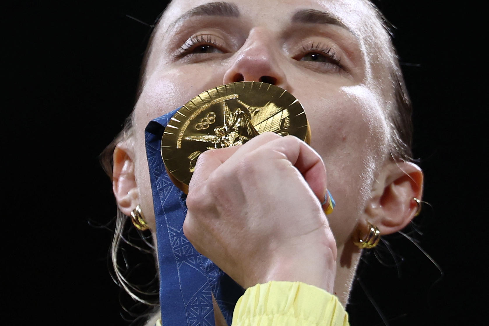 Icône de l'escrime ukrainienne, Olga Kharlan embrasse sa médaille d'or conquise en sabre par équipe, ce dimanche, au Grand Palais. AFP/Franck Fife