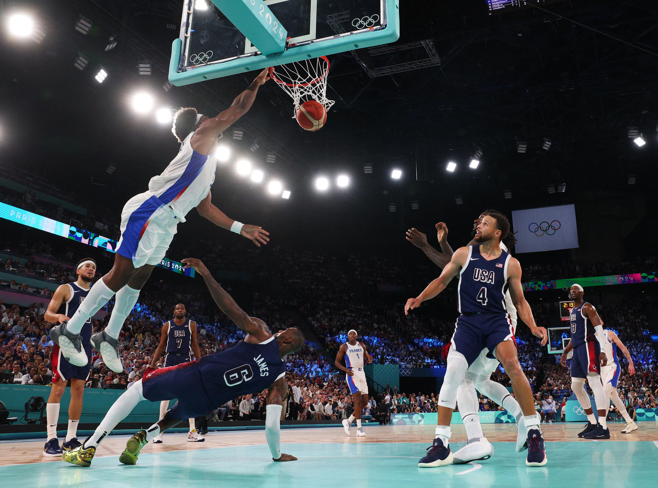 Paris Bercy Arena, le 10 août 2024. Ce panier de Guerschon Yabusele (en blanc) au dessus de la star américaine LeBron James restera comme une des images fortes de la finale de basket remportée par les Etats-Unis. Reuters/Brian Snyder